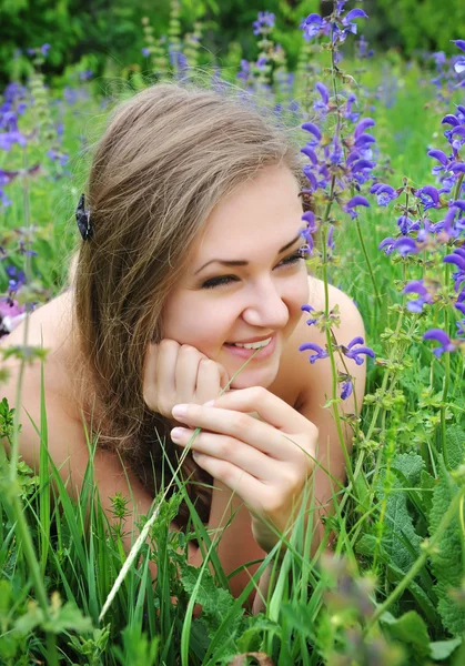Vacker ung kvinna i violetta blommor utomhus — Stockfoto