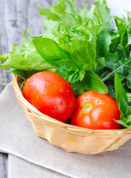 Frisches Gemüse und Grünzeug liegen in einem Korb auf Sacktuch — Stockfoto