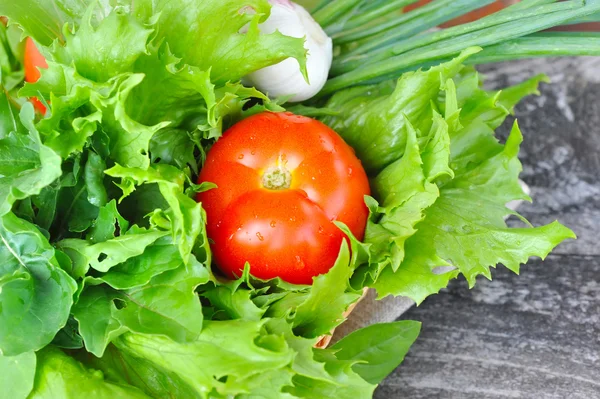 Verduras frescas y vegetación están en una canasta sobre un fondo de madera viejo —  Fotos de Stock