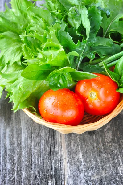 Verduras frescas y vegetación están en una canasta sobre un fondo de madera viejo —  Fotos de Stock