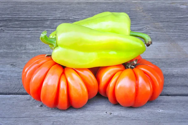 Fresh tomatoes (sort Beauty Lottringa) and sweet green pepper on an old wooden table — Stock Photo, Image