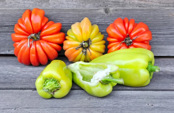 Fresh sweet green peppers and tomatoes (sort Beauty Lottringa) on an old wooden table — Stock Photo, Image