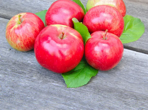 Čerstvá jablka na dřevěné lavičce — Stock fotografie