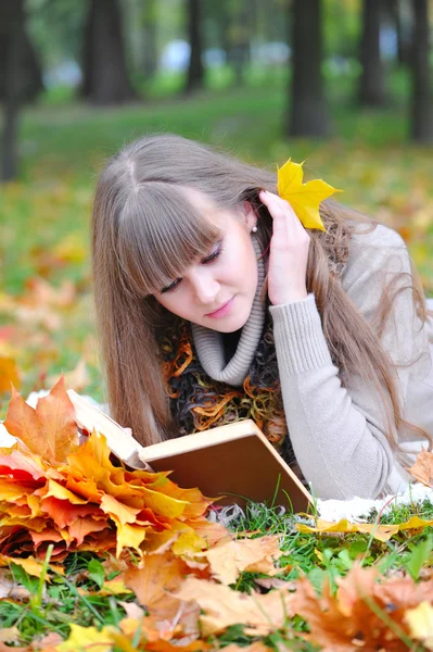 Hermosa chica con libro en el parque de otoño — Foto de Stock