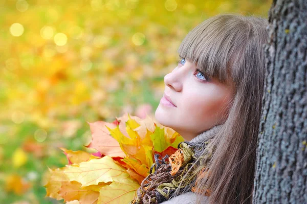 Portrait of beautiful young woman with autumn leaves — Stock Photo, Image