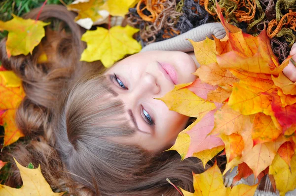 Portrait of beautiful young woman with autumn leaves — Stock Photo, Image