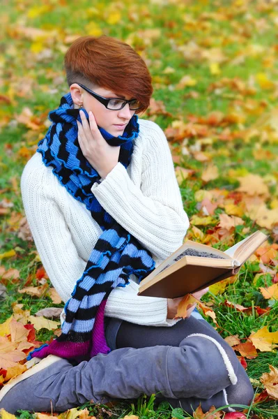 Hermosa chica con libro en el parque de otoño — Foto de Stock