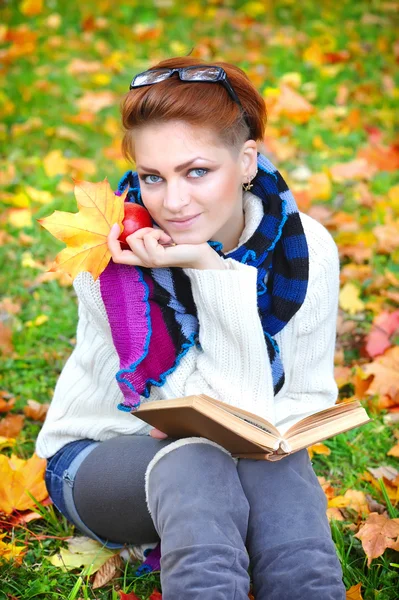 Vacker flicka med bok i höst park — Stockfoto