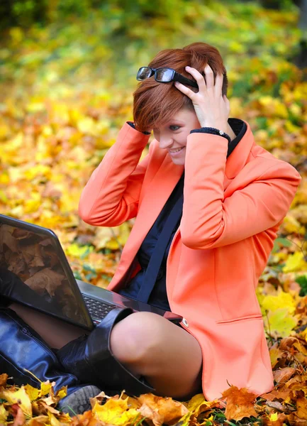 手提电脑在片秋色的公园的可爱女人 — 图库照片
