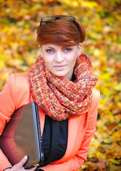 Mujer linda con portátil en el parque de otoño — Foto de Stock