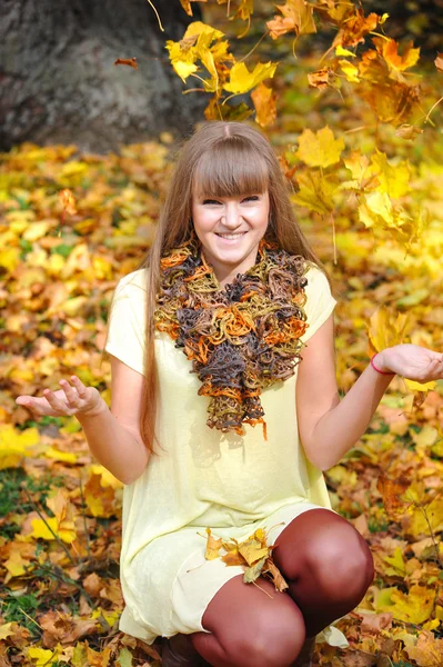 Junges Mädchen im Herbstpark wirft mit Blättern — Stockfoto