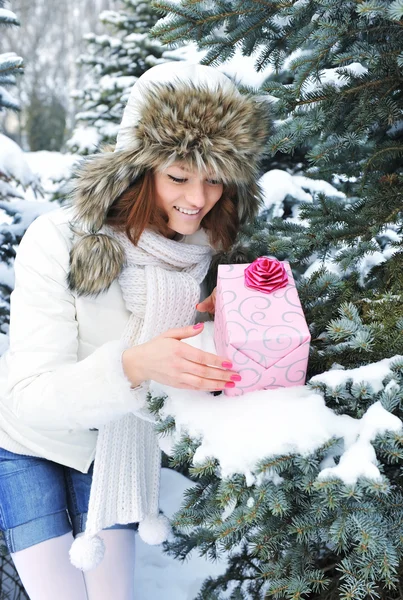 一个年轻的女孩是在冬季公园的一份礼物 — 图库照片