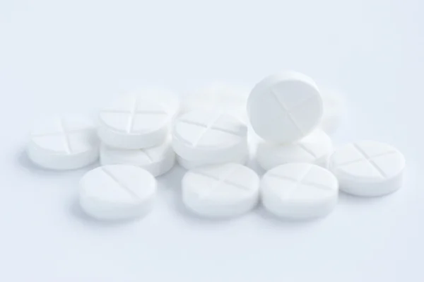 Pílulas brancas no fundo branco — Fotografia de Stock