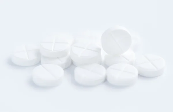 Білі таблетки на білому тлі — стокове фото