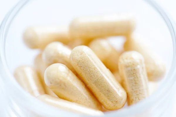 Medical capsules in a glass — Stock Photo, Image