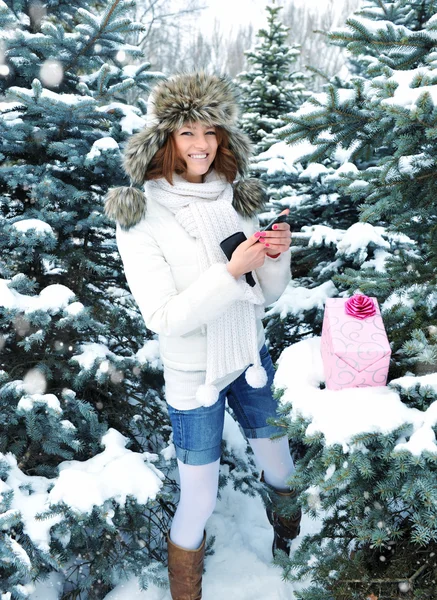 A young girl is with a gift in winter park — Stock Photo, Image