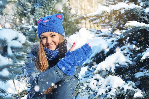 Winter vrouw spelen sneeuwballen op sneeuw achtergrond — Stockfoto