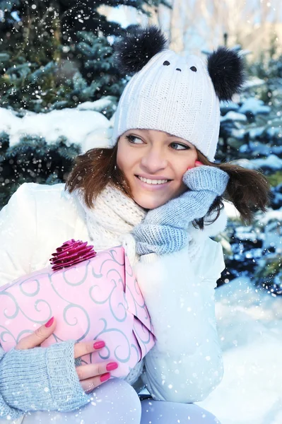 Ein junges Mädchen ist mit einem Geschenk im Winterpark — Stockfoto