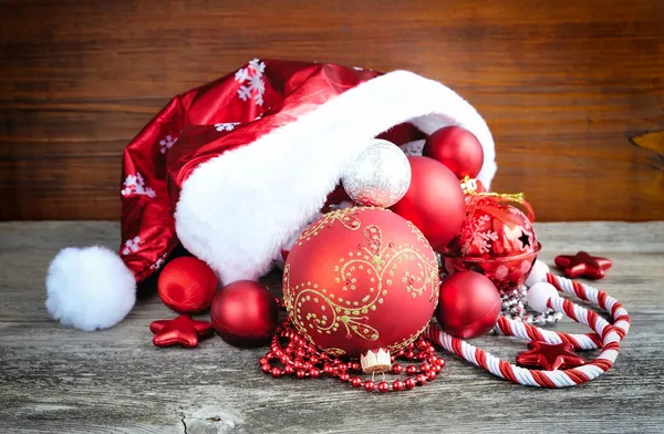 Chapéu Papai Noel com decorações de Natal em fundo de madeira — Fotografia de Stock