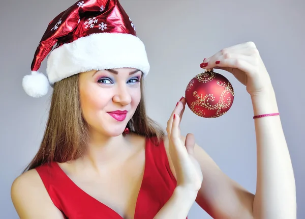 Attractive young woman holding red Christmas ball — Stock Photo, Image