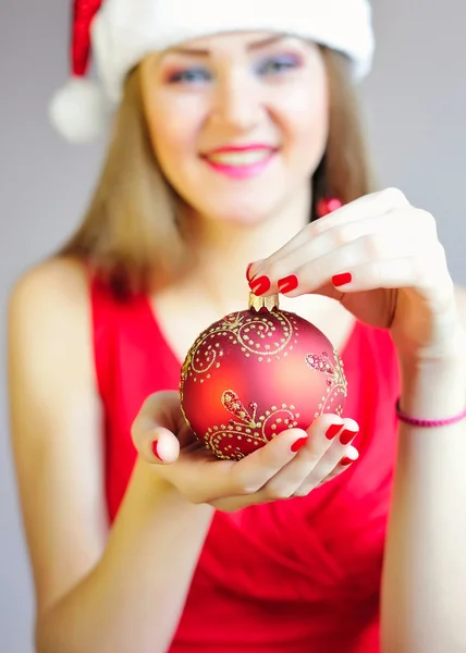赤いドレスを着た女性の手でクリスマス ボールへのクローズ アップ — ストック写真