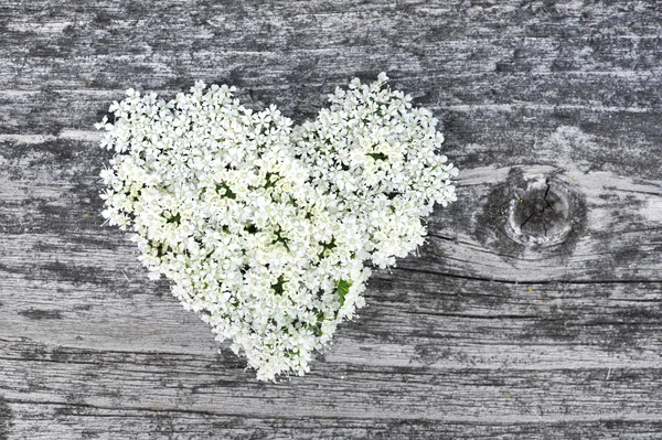 Heart from flowers on old wooden background — Stock Photo, Image