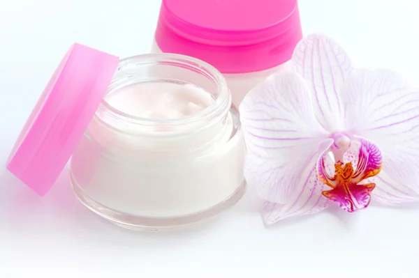 Crèmes pour le visage et belles fleurs d'orchidée sur fond blanc — Photo