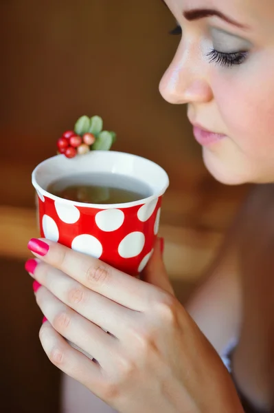 美しい女性コケモモお茶のカップを保持します。 — ストック写真