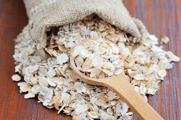 Copos de avena sobre mesa de madera — Foto de Stock