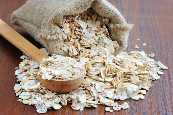 Oat flakes on wooden table — Stock Photo, Image