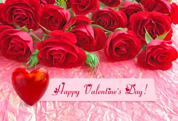 Rote Rosen mit einem Herz auf einem Hintergrund ein Geschenkpapier — Stockfoto