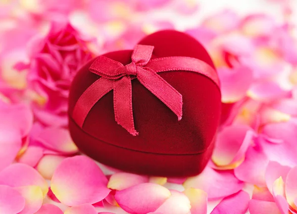 Heart-shaped Gift Box on rose petals — Stock Photo, Image