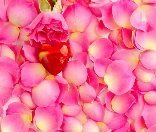 Corazón decorativo sobre pétalos de rosa rosa, fondo romántico —  Fotos de Stock