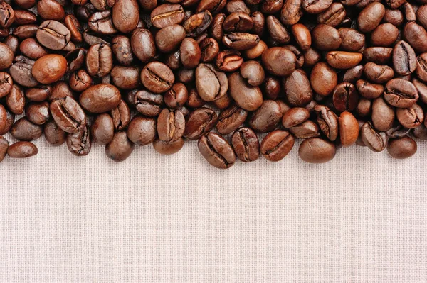 Boabe de cafea pe fundal lenjerie de pat — Fotografie, imagine de stoc