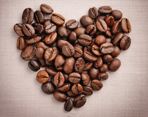 Heart from coffee beans on a linen cloth — Stock Photo, Image