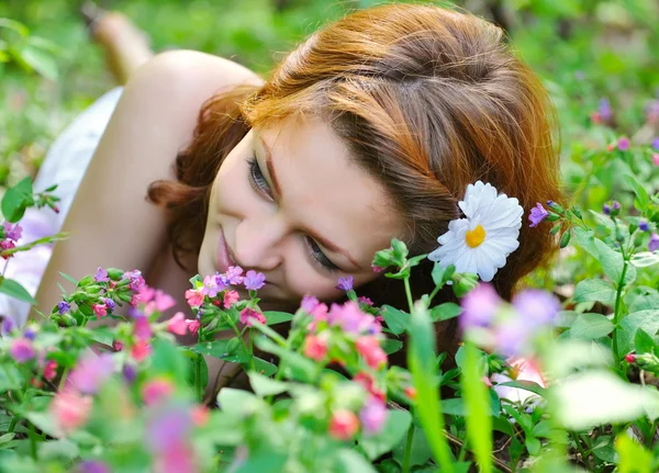 Vacker ung kvinna i skogen med vårblommor — Stockfoto