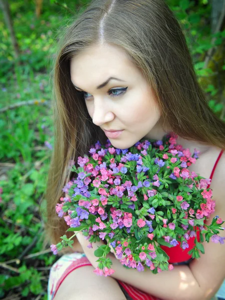 Belle jeune femme avec le bouquet de fleurs de printemps — Photo