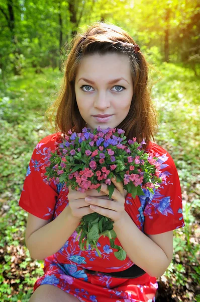 Mulher bonita com o buquê de flores da primavera — Fotografia de Stock