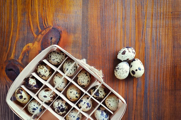 Перепелиные яйца в деревянной коробке, упаковка, поднос на деревянном фоне — стоковое фото