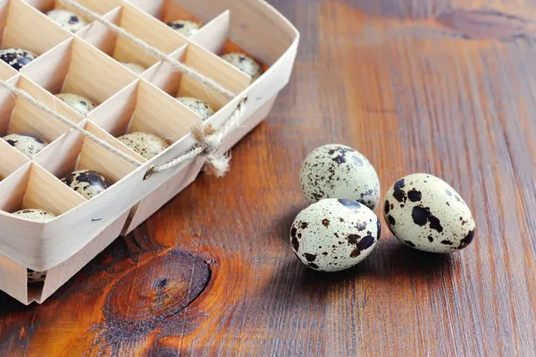 Перепелиные яйца в деревянной коробке, упаковка, поднос на деревянном фоне — стоковое фото