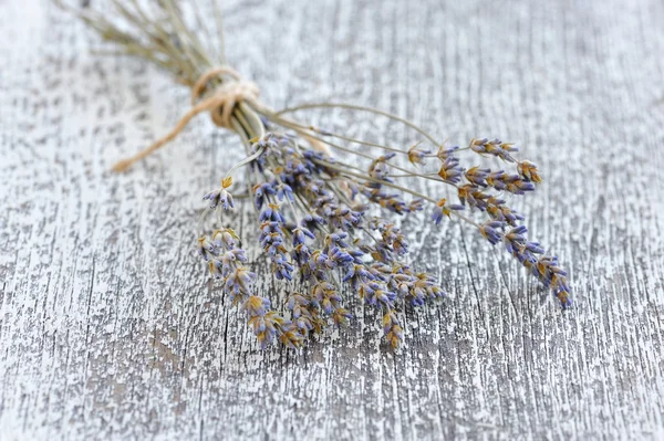 Bando de lavanda seca em uma velha mesa de madeira — Fotografia de Stock