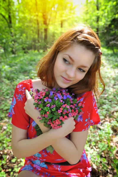 Mooie jonge vrouw met het boeket van Lentebloemen — Stockfoto