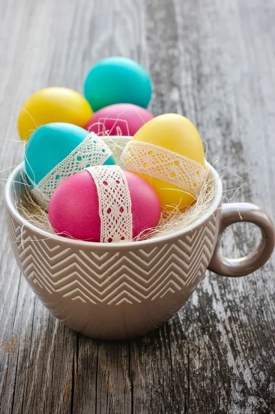 Ovos de Páscoa coloridos em uma xícara decorativa — Fotografia de Stock