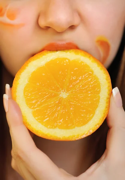 Giovane bella donna mangiare un'arancia — Foto Stock