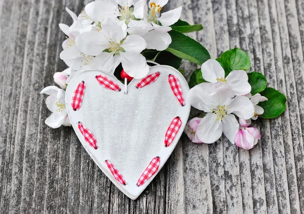 Jarní květy a srdce dřevěné pozadí — Stock fotografie