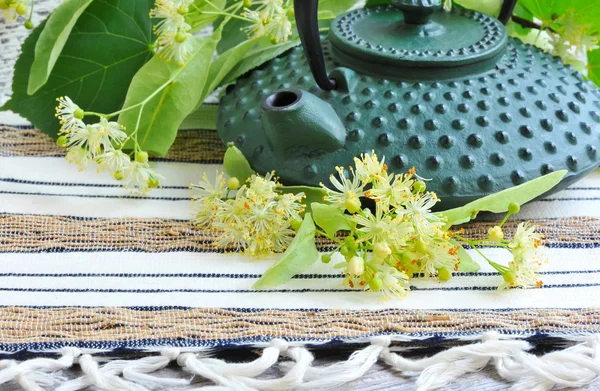Theepot met linden thee en bloemen — Stockfoto