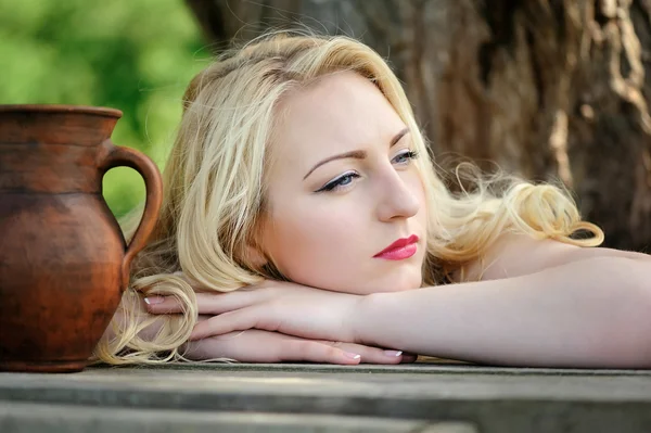 Portrait of a beautiful blonde woman with a ceramic jug — Stock Photo, Image