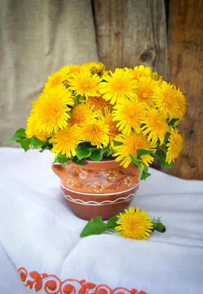 Dandelions seramik bir sürahi içinde buket — Stok fotoğraf