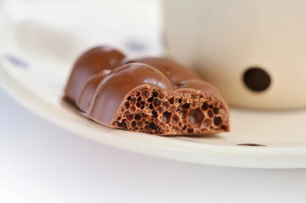Пористый чёрный шоколад на блюдце крупным планом — стоковое фото