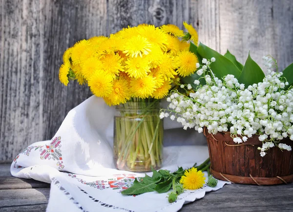 Dandelions ve vadideki zambak (convallaria majalis demetleri) — Stok fotoğraf